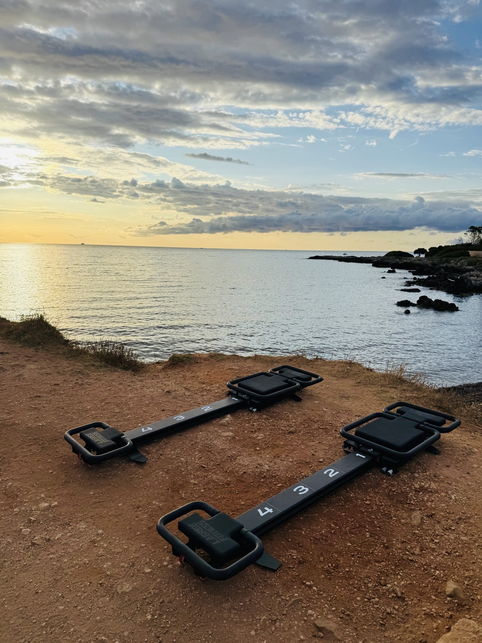 Deux machines Lagree installées face à la mer au coucher du soleil